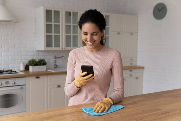 istock Happy young hispanic female polish kitchen and use smartphone app 1313525152