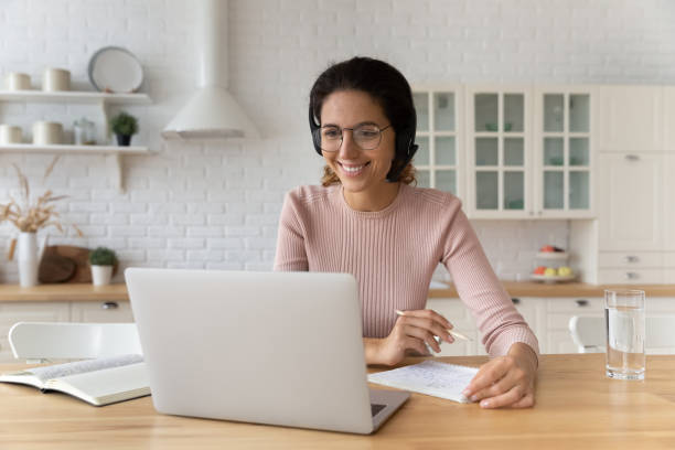 istock Smiling hispanic female student in earphones look on pc screen 1313525211