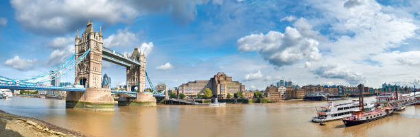 istock Tower Bridge on a bright sunny day with blue sky and clouds. Calm water with reflections. London, England, UK 1313526946