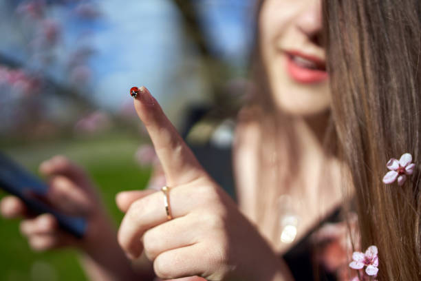 Young woman with a ladybug on her finger, smiling