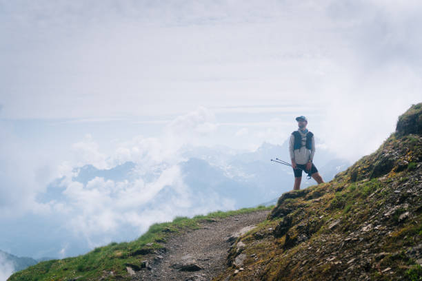 istock Trail runner pauses on mountain trail in mist 1313530778