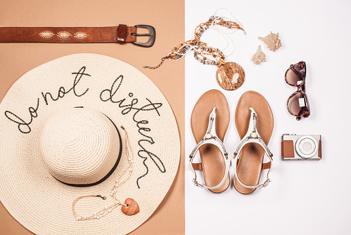 Woman Summer Personal Accessories with White Sandals and Straw Hat on White and Beige Background