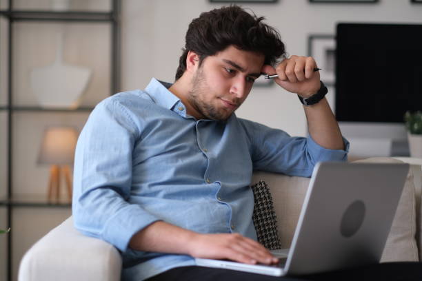 istock Teenage boy using laptop at home 1313532673