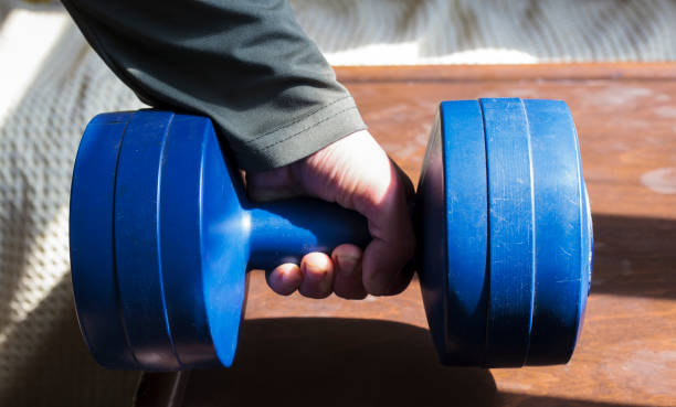 istock Young man lifting weights in his home. 1313534291