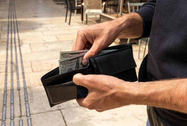 czarny portfel u mężczyzn ręka. mężczyzna sprawdza gotówkę w portfelu. - spending money currency allowance wallet zdjęcia i obrazy z banku zdjęć