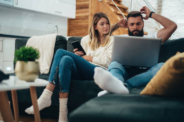 istock Couple using smartphone and a laptop at home 1313535246