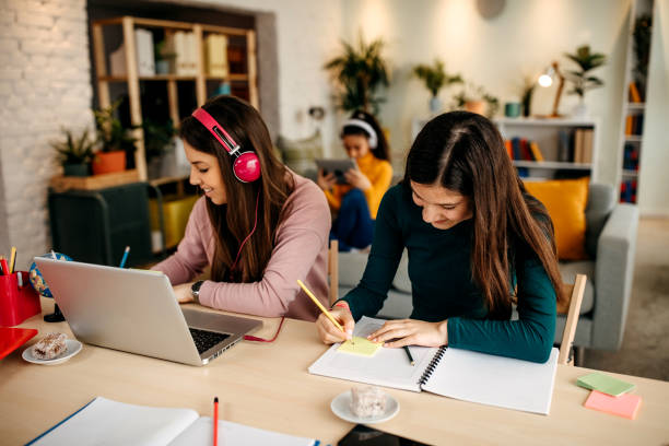 istock Mother and daughter study together at home, while the other sings on the bed using a tablet 1313537618