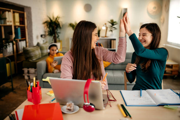 istock Mother and daughter study together at home, while the other sings on the bed using a tablet 1313538603