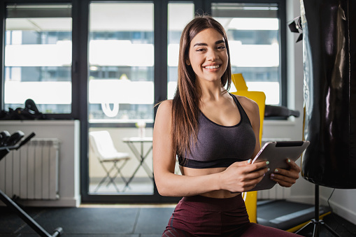 Portrait of woman holding a tablet in her gym studio