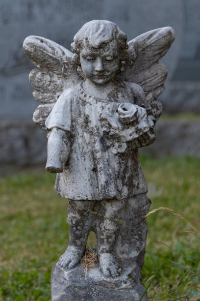 istock Sweet Old Angel Statue in a Graveyard 1313540640