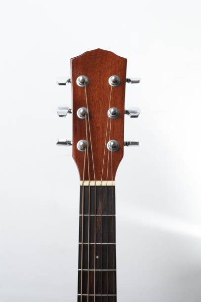 istock Acoustic guitar neck with tuning pegs on a white background 1313544669