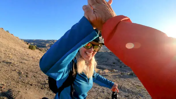 Photo of Female mountain biker reaches up for a high five after ride