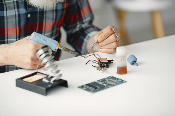 istock Male tech repairs electronic equipment at home 1313549552