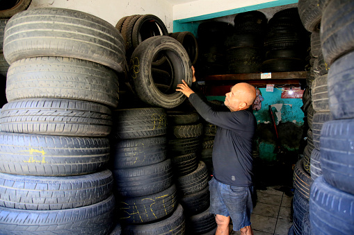 salvador, bahia, brazil - december 9, 2020: a tire repairman makes repairs on a flat tire in the city of Salvador.