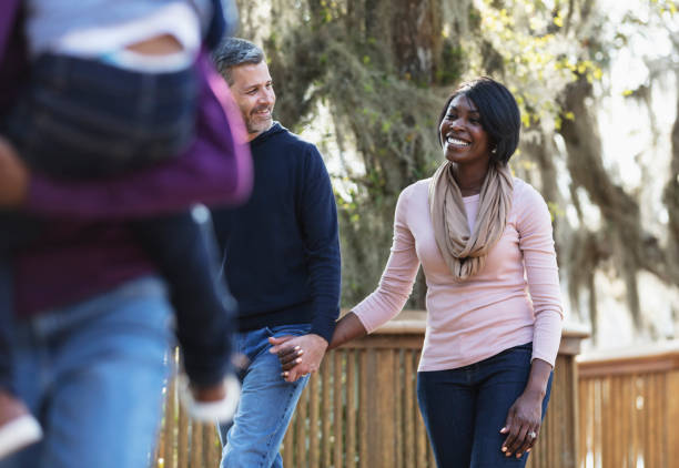 istock Interracial couple walking in park holding hands 1313552931