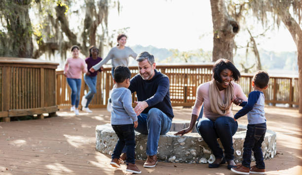 istock Interracial family with twin boys playing on park deck 1313553074