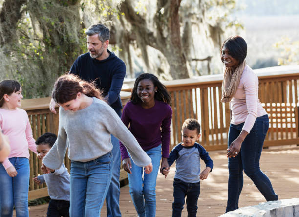 istock Blended family with five children walking in park 1313553088