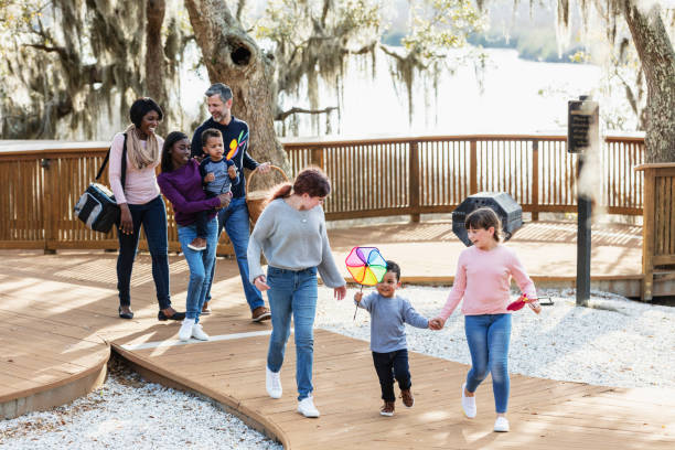 istock Blended family with five children walking in park 1313553112