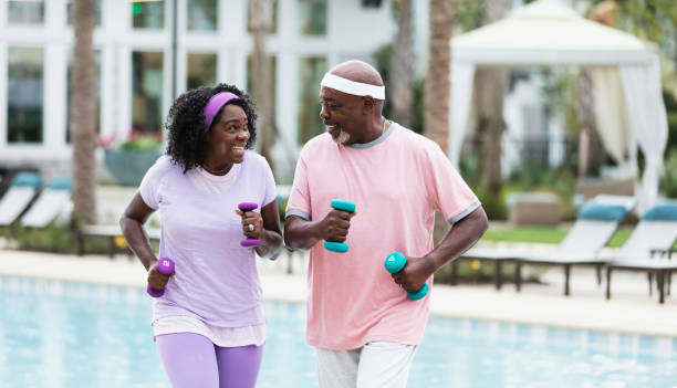 istock Senior African-American couple exercising on pool deck 1313553363