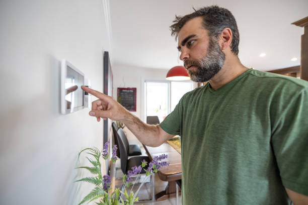 istock Man Using Home Automation on Digital Tablet to Open Lights in Kitchen and dining room 1313553485
