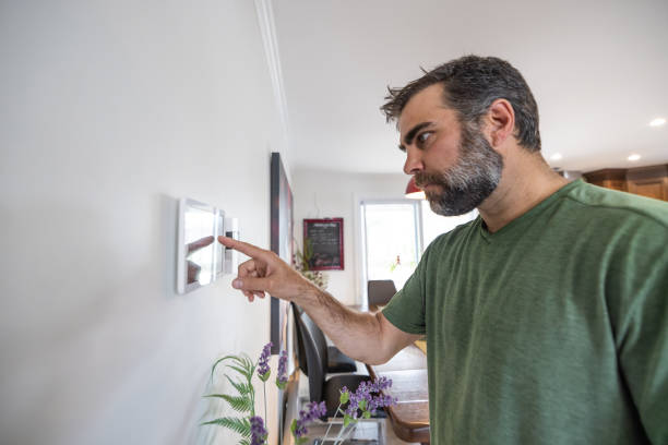 istock Man Using Home Automation on Digital Tablet to Open Lights in Kitchen and dining room 1313554077