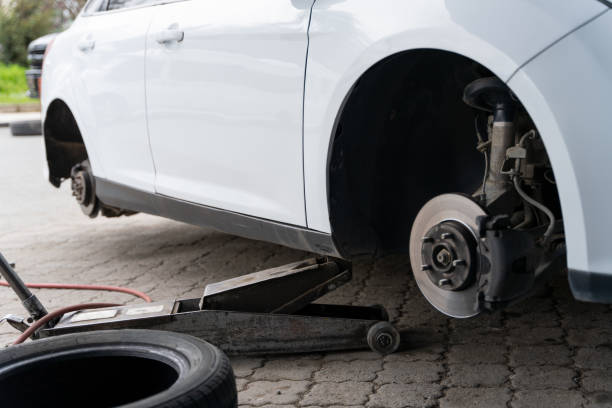 istock white car raised with a jack to change its tires 1313555947