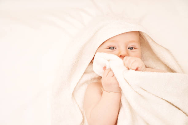 istock Cute small boy lying at bed. Childhood bath concept. Light background 1313556152