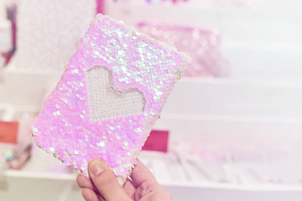 Notebook with anti-stress sequin cover in woman hand.