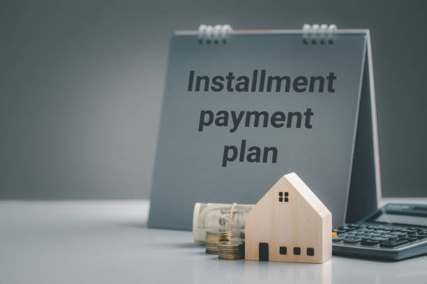 istock Model house and dollar bill with coins, calculator, Housing installment plans concept. 1313574166