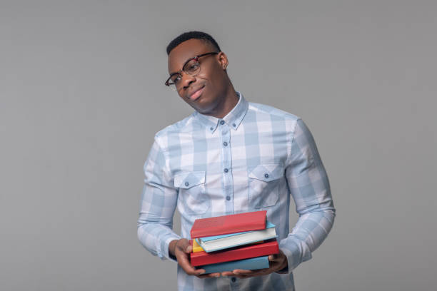 istock Satisfied man in glasses with textbooks 1313574870