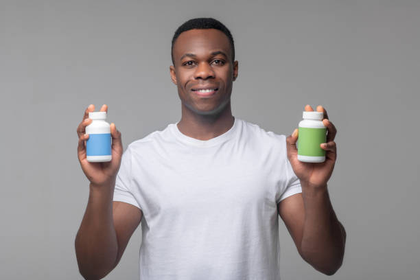 istock Glad man holding package of vitamins in hands 1313574894