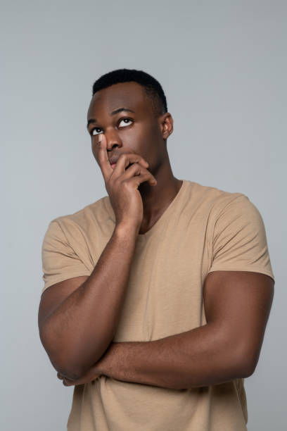 istock Young pensive african american man standing in studio photo 1313574942