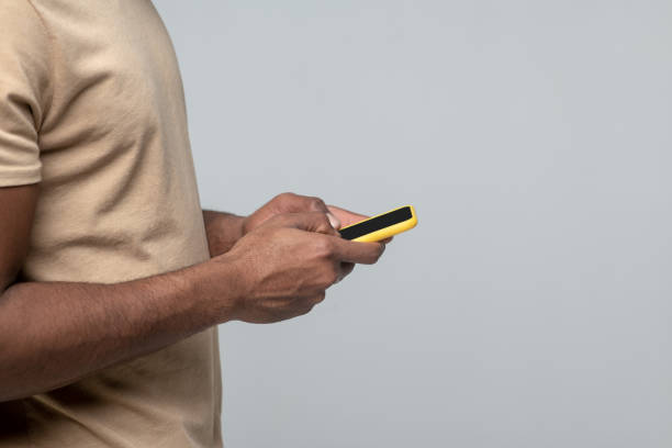 istock Hands of man standing sideways with smartphone 1313574960