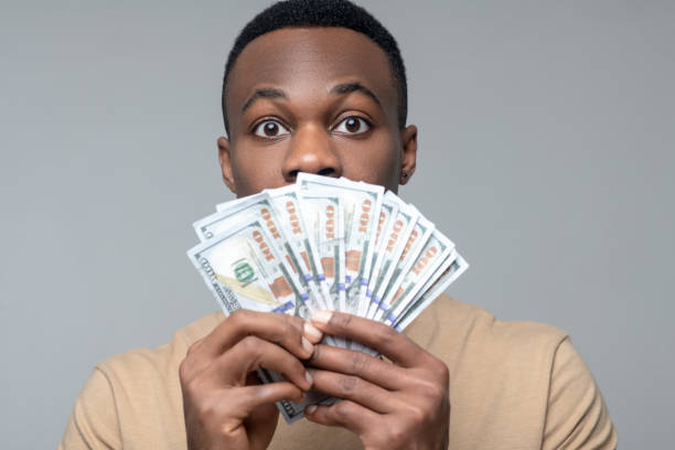 istock Man holding banknotes near his face 1313574984