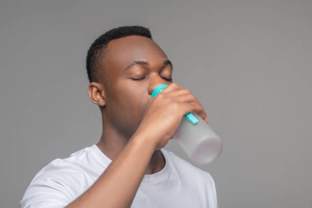 istock Man with closed eyes drinking water from bottle 1313575164