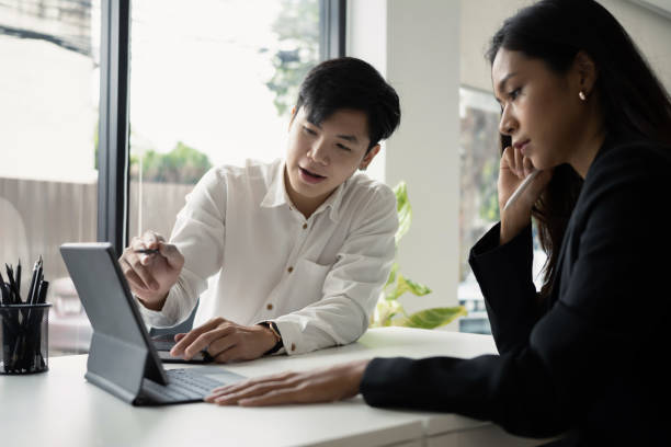 istock Two young businesspeople discussing project and sharing ideas in office. 1313589258