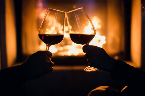 istock Young couple have romantic dinner with wine over fireplace background 1313590193