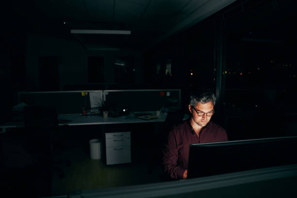 istock Middle age businessman working at his desktop computer till late night in office 1313590379