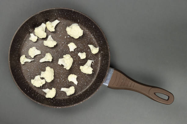 istock Raw cauliflower in frying pan on grey background 1313593385