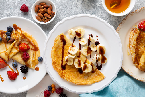 Overhead view of breakfast crepes with banana and berries