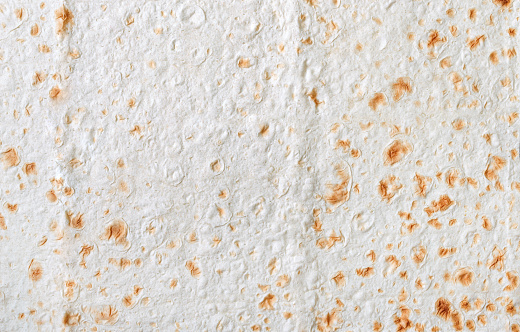 Texture of thin traditional freshly baked homemade oriental bread. Close-up Armenian and Turkish unleavened flat bread. Textured lavash background.