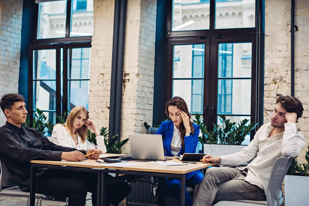 istock Sad businesspeople thinking at table in office 1313597570