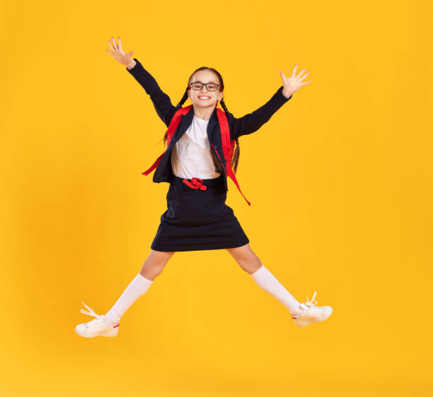 istock Excited schoolgirl jumping high in studio 1313605714