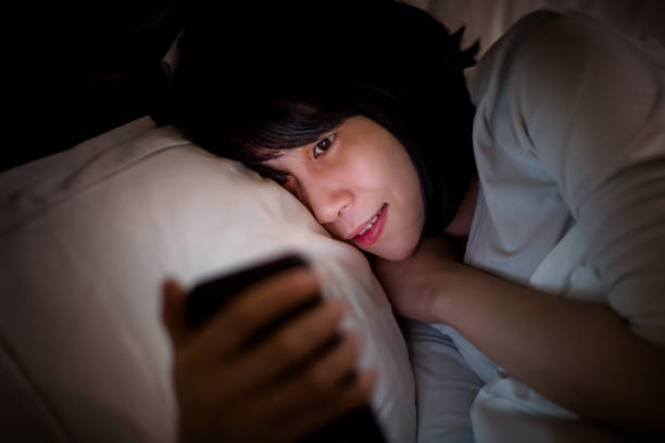 istock Young woman looking at smartphone in bed 1313606111
