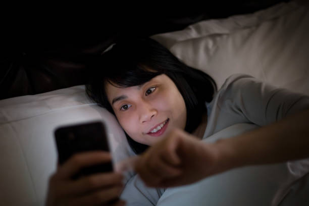 istock Young woman lying in bed using a smartphone 1313606137