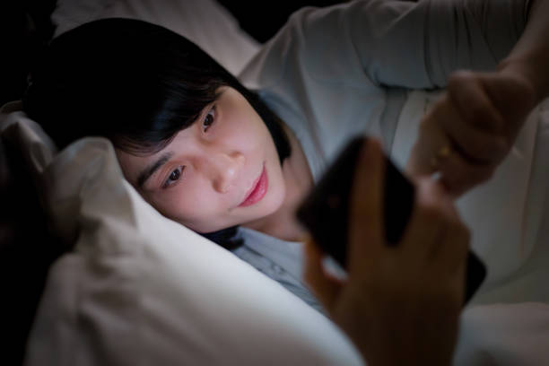 istock Young woman lying in bed using a smartphone 1313606145