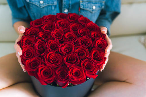 Woman holding a gorgeous bouquet. Red roses