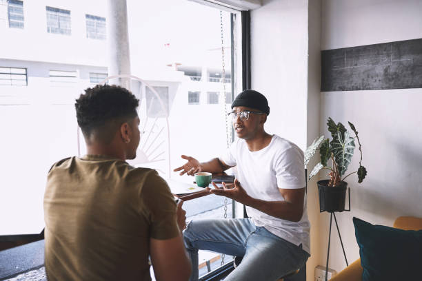 istock Shot of two young men talking while having coffee together in a cafe 1313610893
