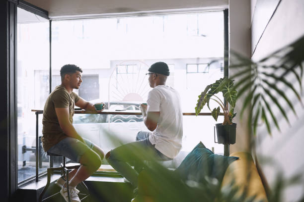 istock Shot of two young men talking while having coffee together in a cafe 1313610898