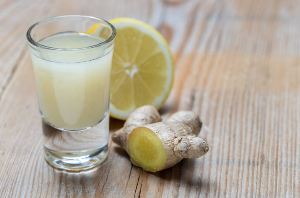 istock Ginger shot with lemon on wooden background 1313612102